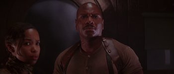 Movie still from “Rosewood” (1997), directed by John Singleton – A man in a brown shirt and brown suspenders looking at the camera; Close Up shot, Low angle