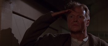 Movie still from “Rosewood” (1997), directed by John Singleton – A person holding his hand to his head; Close Up shot, Low angle