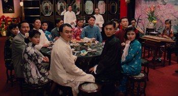Movie still from “Rouge” (1987), directed by Stanley Kwan – A group of people sitting around a table with food on top of it; Wide shot, High angle