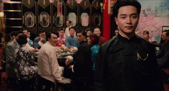 Movie still from “Rouge” (1987), directed by Stanley Kwan – A group of people sitting around a table; Medium shot, Over the shoulder angle