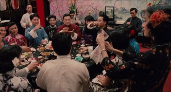 Movie still from “Rouge” (1987), directed by Stanley Kwan – A group of people sitting around a dinner table; Wide shot, High angle