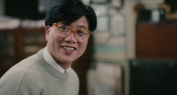 Movie still from “Rouge” (1987), directed by Stanley Kwan – A person wearing glasses and a sweater; Close Up shot, Low angle