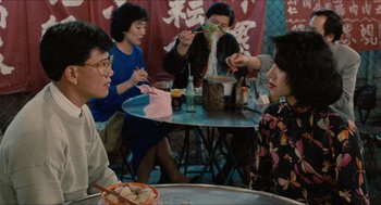 Movie still from “Rouge” (1987), directed by Stanley Kwan – A group of people sitting around a table; Medium shot, Over the shoulder angle