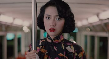 Movie still from “Rouge” (1987), directed by Stanley Kwan – A woman in a floral dress holding onto a pole; Close Up shot, High angle