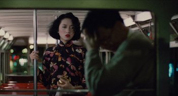 Movie still from “Rouge” (1987), directed by Stanley Kwan – A man and a woman are standing next to each other on a train; Medium shot, Over the shoulder angle