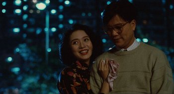Movie still from “Rouge” (1987), directed by Stanley Kwan – A man and a woman posing for a picture in front of lights; Medium shot, Over the shoulder angle