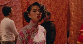 Movie still from “Rouge” (1987), directed by Stanley Kwan – A woman in a floral dress standing in front of a wall; Medium shot, Over the shoulder angle