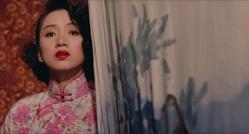 Movie still from “Rouge” (1987), directed by Stanley Kwan – A woman in a floral dress standing in front of a wall; Medium shot, Low angle