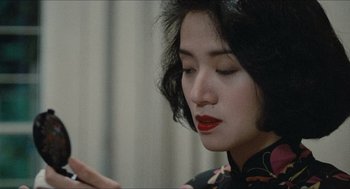 Movie still from “Rouge” (1987), directed by Stanley Kwan – A woman with red lipstick looking down at her hand; Close Up shot, Over the shoulder angle