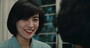 Movie still from “Rouge” (1987), directed by Stanley Kwan – A woman with short black hair smiling for the camera; Close Up shot, Over the shoulder angle