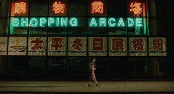 Movie still from “Rouge” (1987), directed by Stanley Kwan – A person walking in front of an arcade sign lit up at night; Extreme Wide shot, Low angle
