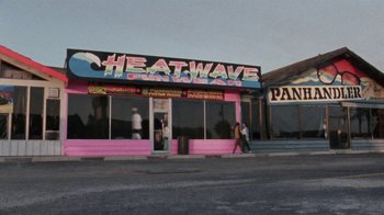 Movie still from “Ruby in Paradise” (1993), directed by Victor Nunez – People walking in front of a store with a pink facade; Extreme Wide shot, High angle