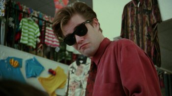 Movie still from “Ruby in Paradise” (1993), directed by Victor Nunez – A young man wearing a red shirt and sunglasses; Close Up shot, Low angle