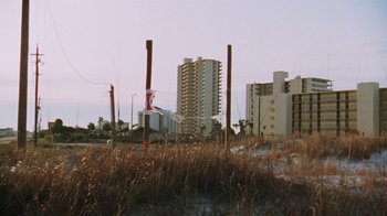Movie still from “Ruby in Paradise” (1993), directed by Victor Nunez – A view of a beach with tall buildings in the background; Extreme Wide shot, Low angle