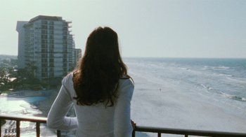 Movie still from “Ruby in Paradise” (1993), directed by Victor Nunez – A woman standing on a balcony looking out at the ocean; Medium shot, Over the shoulder angle