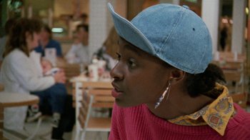 Movie still from “Ruby in Paradise” (1993), directed by Victor Nunez – A woman wearing a blue hat sitting at a table in a restaurant; Close Up shot, Over the shoulder angle