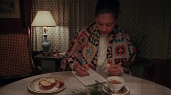 Movie still from “Ruby in Paradise” (1993), directed by Victor Nunez – A woman sitting at a table writing on a notebook; Medium shot, High angle