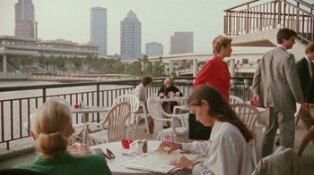 Movie still from “Ruby in Paradise” (1993), directed by Victor Nunez – A group of people sitting at tables on a deck; Extreme Wide shot, High angle