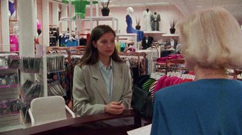 Movie still from “Ruby in Paradise” (1993), directed by Victor Nunez – A woman sitting at a table in a clothing store; Medium shot, Over the shoulder angle