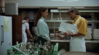 Movie still from “Ruby in Paradise” (1993), directed by Victor Nunez – A woman and a man are standing in a kitchen; Medium shot, Over the shoulder angle