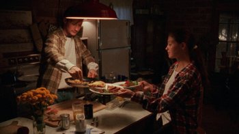 Movie still from “Ruby in Paradise” (1993), directed by Victor Nunez – A man and a woman are serving food at a table; Wide shot, High angle