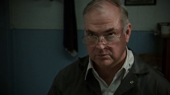 Movie still from “Ruby in Paradise” (1993), directed by Victor Nunez – An older man wearing glasses and a black jacket; Close Up shot, Over the shoulder angle