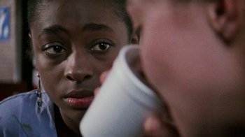 Movie still from “Ruby in Paradise” (1993), directed by Victor Nunez – A young boy looking into a mirror while holding a cup; Close Up shot, Over the shoulder angle