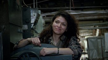 Movie still from “Ruby in Paradise” (1993), directed by Victor Nunez – A woman in a plaid shirt leaning on a machine; Medium shot, Over the shoulder angle