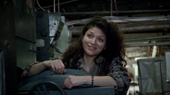 Movie still from “Ruby in Paradise” (1993), directed by Victor Nunez – A young woman smiles while leaning on a vehicle; Medium shot, Low angle