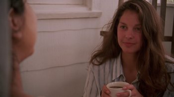 Movie still from “Ruby in Paradise” (1993), directed by Victor Nunez – A woman holding a cup of coffee while sitting in a room; Close Up shot, Over the shoulder angle