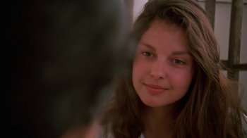 Movie still from “Ruby in Paradise” (1993), directed by Victor Nunez – A young girl is smiling for the camera; Close Up shot, Over the shoulder angle