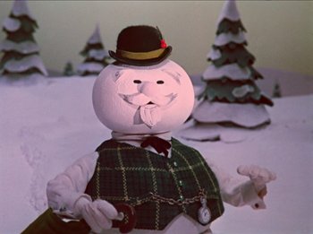 Movie still from “Rudolph the Red-Nosed Reindeer” (1964), directed by Larry Roemer – A snowman with a chain around his neck; Medium shot, Low angle