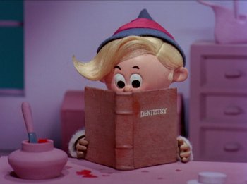Movie still from “Rudolph the Red-Nosed Reindeer” (1964), directed by Larry Roemer – A cartoon character is reading a book; Medium shot, Low angle