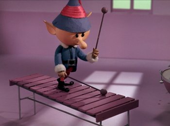 Movie still from “Rudolph the Red-Nosed Reindeer” (1964), directed by Larry Roemer – An animated elf is playing the xylophone; Wide shot, Low angle