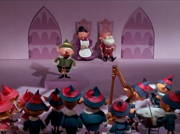 Movie still from “Rudolph the Red-Nosed Reindeer” (1964), directed by Larry Roemer – A group of toy dwarfs sitting in front of a stage; Wide shot, Low angle