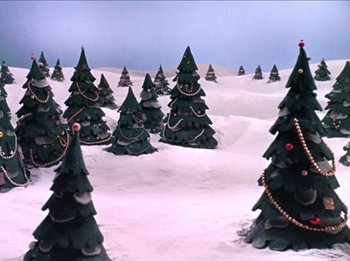 Movie still from “Rudolph the Red-Nosed Reindeer” (1964), directed by Larry Roemer – Many christmas trees in the snow; Extreme Wide shot, High angle
