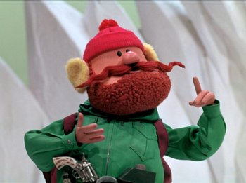 Movie still from “Rudolph the Red-Nosed Reindeer” (1964), directed by Larry Roemer – A person with a red hat and a green jacket; Close Up shot, Low angle