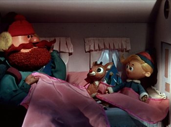 Movie still from “Rudolph the Red-Nosed Reindeer” (1964), directed by Larry Roemer – A group of gnomes and a reindeer in a bed; Medium shot, Low angle