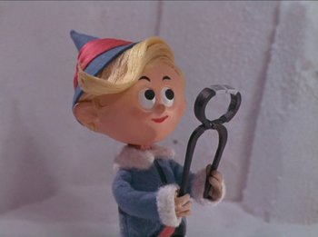Movie still from “Rudolph the Red-Nosed Reindeer” (1964), directed by Larry Roemer – A figurine holding an object in its hands; Close Up shot, Low angle