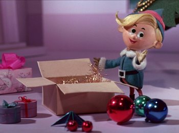 Movie still from “Rudolph the Red-Nosed Reindeer” (1964), directed by Larry Roemer – A toy elf is opening a box of christmas ornaments; Medium shot, Low angle