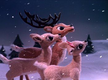 Movie still from “Rudolph the Red-Nosed Reindeer” (1964), directed by Larry Roemer – A group of stuffed deer standing next to each other in the snow; Medium shot, Low angle