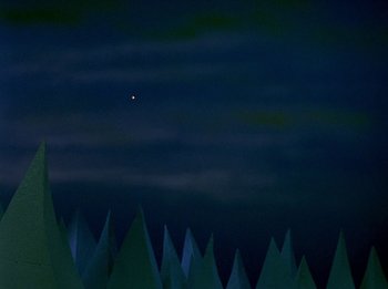 Movie still from “Rudolph the Red-Nosed Reindeer” (1964), directed by Larry Roemer – A view of a forest at night with a sky filled with stars; Extreme Wide shot, Low angle
