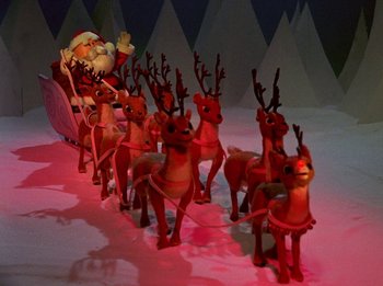 Movie still from “Rudolph the Red-Nosed Reindeer” (1964), directed by Larry Roemer – A group of plastic reindeer and a santa clause in a sleigh; Wide shot, High angle