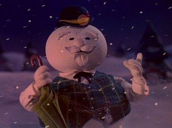 Movie still from “Rudolph the Red-Nosed Reindeer” (1964), directed by Larry Roemer – A man in a suit and tie holding a cane; Close Up shot, Low angle