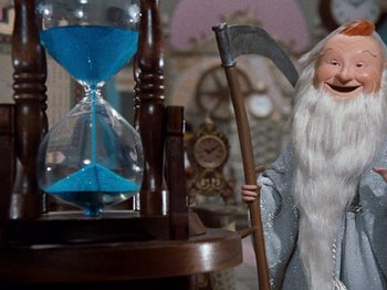 Movie still from “Rudolph's Shiny New Year” (1976), directed by Jules Bass – An image of an old man holding a scythe; Medium shot, Low angle