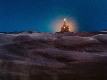 Movie still from “Rudolph's Shiny New Year” (1976), directed by Jules Bass – A light shining on a building on top of a hill; Extreme Wide shot, Low angle