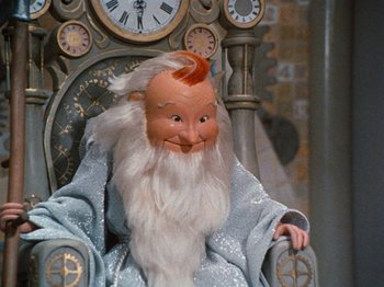 Movie still from “Rudolph's Shiny New Year” (1976), directed by Jules Bass – A doll of a wizard sitting in a chair; Medium shot, Low angle
