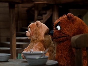 Movie still from “Rudolph's Shiny New Year” (1976), directed by Jules Bass – Two teddy bears sitting next to each other on a table; Medium shot, Over the shoulder angle