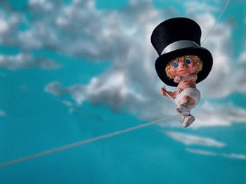 Movie still from “Rudolph's Shiny New Year” (1976), directed by Jules Bass – A doll with a top hat hanging from a wire; Wide shot, Low angle