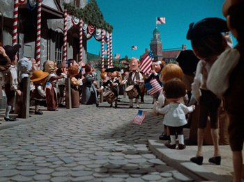 Movie still from “Rudolph's Shiny New Year” (1976), directed by Jules Bass – A group of people standing on a brick road; Wide shot, High angle